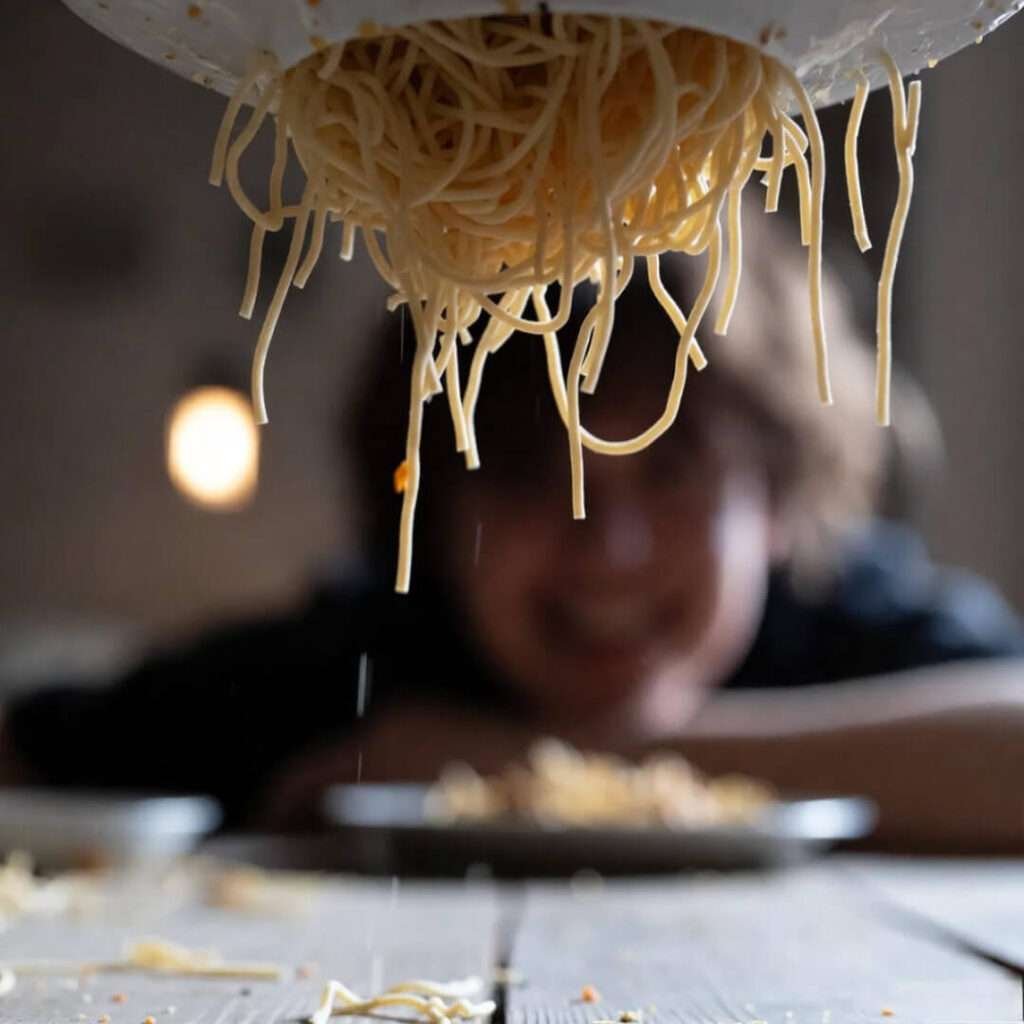 Dangling noodles taunt below table.