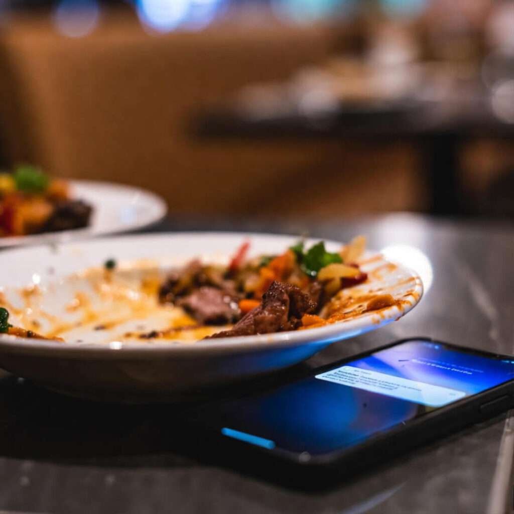 Messy plate, sauce splatter, phone glowing.